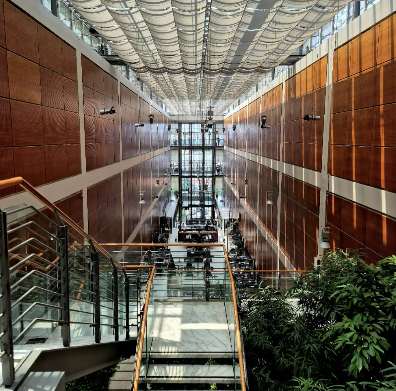 Interno moderno della biblioteca centrale “Norberto Bobbio” Politecnico di Torino al Lingotto, con vetrate, pareti in legno e tetto ondulato.
