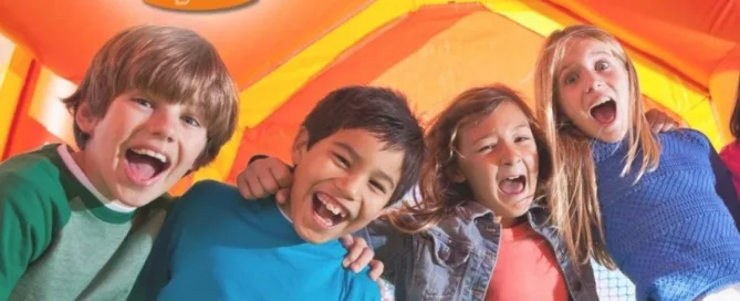 Gruppo di bambini che giocano insieme dentro un grande gonfiabile arancione al LingottoLand, spazio divertimento del Lingotto Torino.